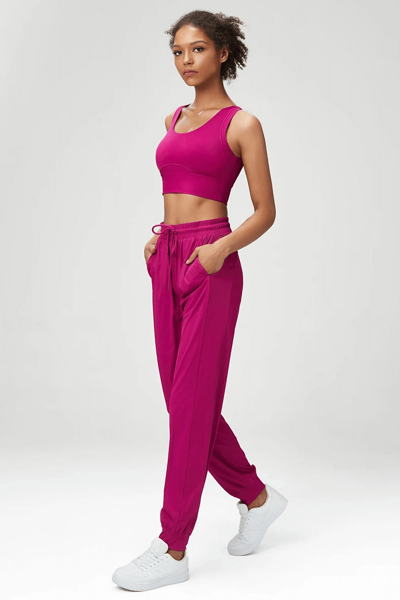 Woman wearing vibrant pink joggers and sports bra set, perfect for both style and comfort. SF2089 fitness fashion.